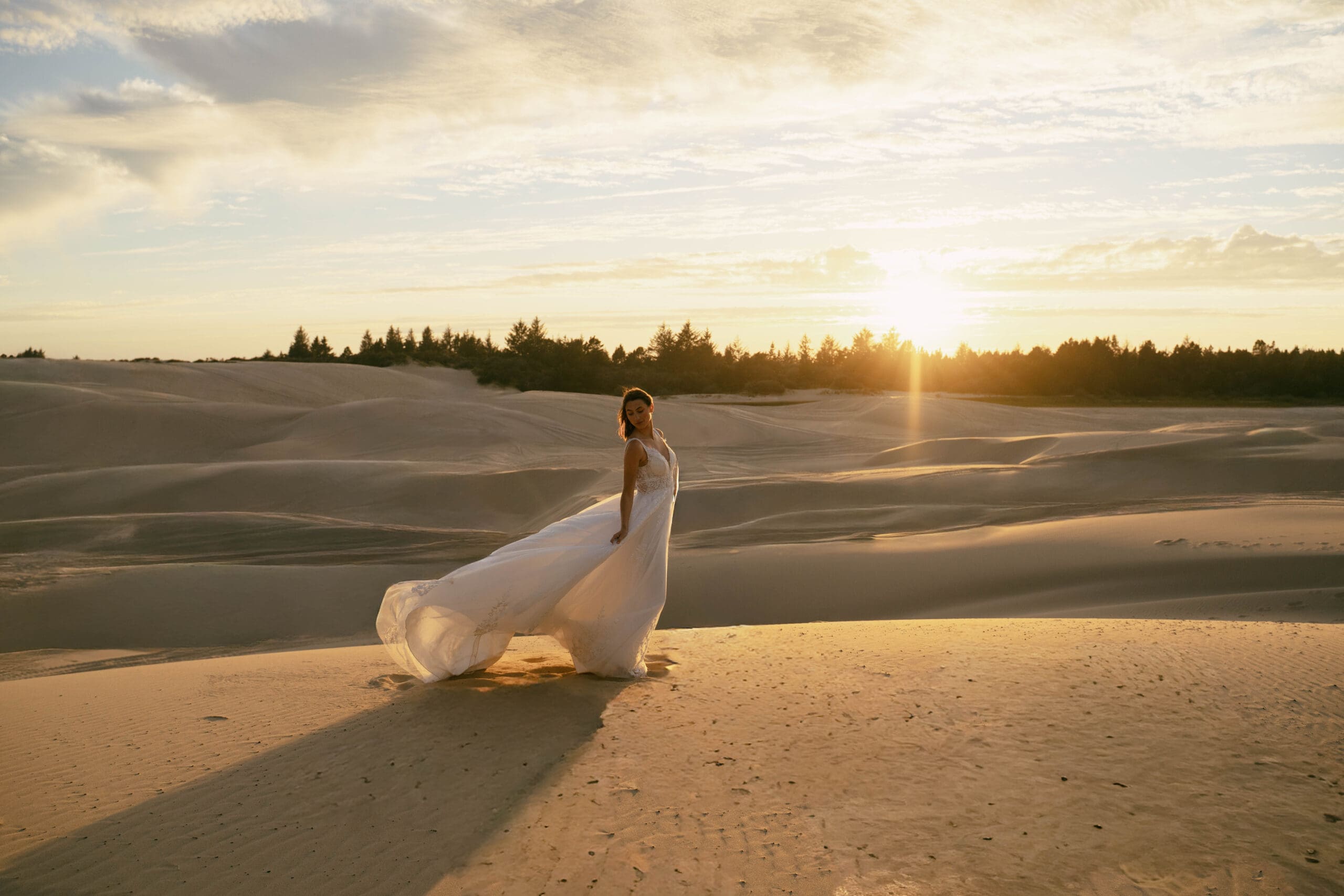 Ethereal bride walking through the sand dunes at sunset during a romantic bridal photoshoot in Florence, Oregon